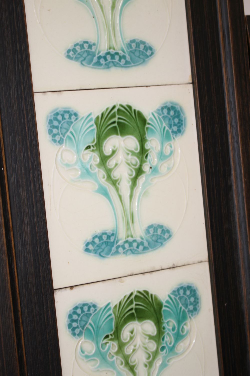 A pair of Victorian apple blossom tile panels and a set of six Art Nouveau foliate design tiles, all framed